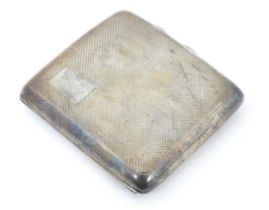 A silver cigarette case with engine turned decoration opening to reveal a gilded interior,