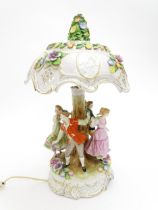 A Schierholz ceramic figural table lamp modelled as figures dancing around a tree, the shade with