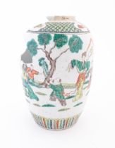 A Chinese famille verte vase decorated with figures in a garden with banded borders. Approx. 11 3/4"