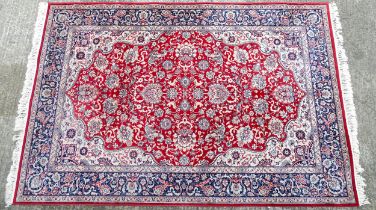 Carpet / Rug : A red ground rug decorated with floral and foliate detail with stylised animals, with
