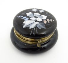 A small glass lidded pot with hand painted enamel flower decoration. Approx 2 3/4" wide Please