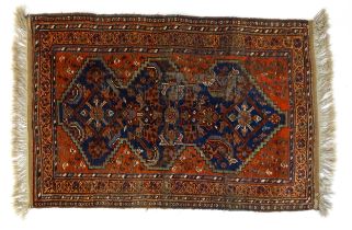 Carpet / Rug : A red and blue ground rug. decorated with floral foliate and scroll detail. Approx.