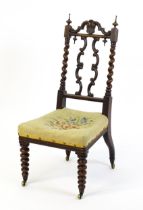 A Victorian rosewood side chair surmounted by turned finials and having barley twist uprights, the