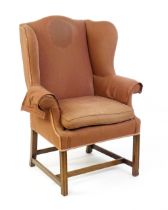 A late 19thC wingback armchair with scrolled arms and raised on chamfered legs united by a H -