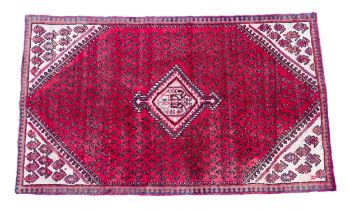 Carpet / Rug : A red ground rug decorated with central cream ground medallion, with repeating motifs