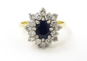 An 18ct gold ring set with a central sapphire bordered by diamonds. Ring size approx. J 1/2 Please