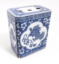 A Chinese blue and white flower brick decorated with foo dogs within vignettes bordered by prunus
