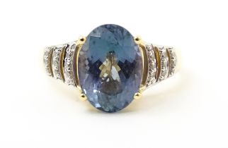 A 14ct gold ring set with central tanzanite flanked by diamonds. Ring size approx. N Please Note -
