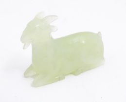 An Oriental carved jade coloured hardstone model of a seated goat. Approx. 1 3/4" long Please Note -
