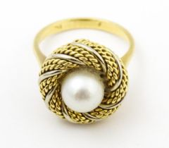 An 18ct gold ring set with central pearl and rope twist detail. Ring size approx. P Please Note - we
