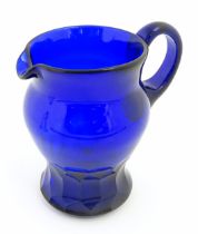 A 19thC Blue glass jug with loop handle and banded facet cut detail. Approx 7 1/2" high Please