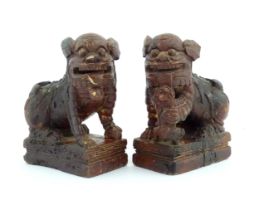 Two Chinese carved wooden foo dogs / guardian lions, one with a cub, the other with a ball, with