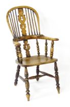 A mid 19thC Windsor chair with a double bow back, pierced back splat and swept arms above a shaped