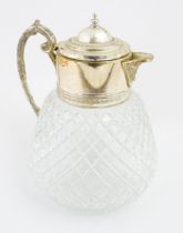 A large glass jug with silver plate mounts and handle Approx 10" high Please Note - we do not make