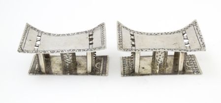 A pair of white metal knife rests formed as African tribal Ashanti / Asante stools. Approx. 2 3/4"