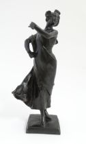 An Art Nouveau cast bronze figure modelled as a lady dancing with a flower in her hair. Indistinctly