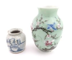 A Chinese celadon vase with hand painted bird and blossom detail. Together with a Chinese blue and