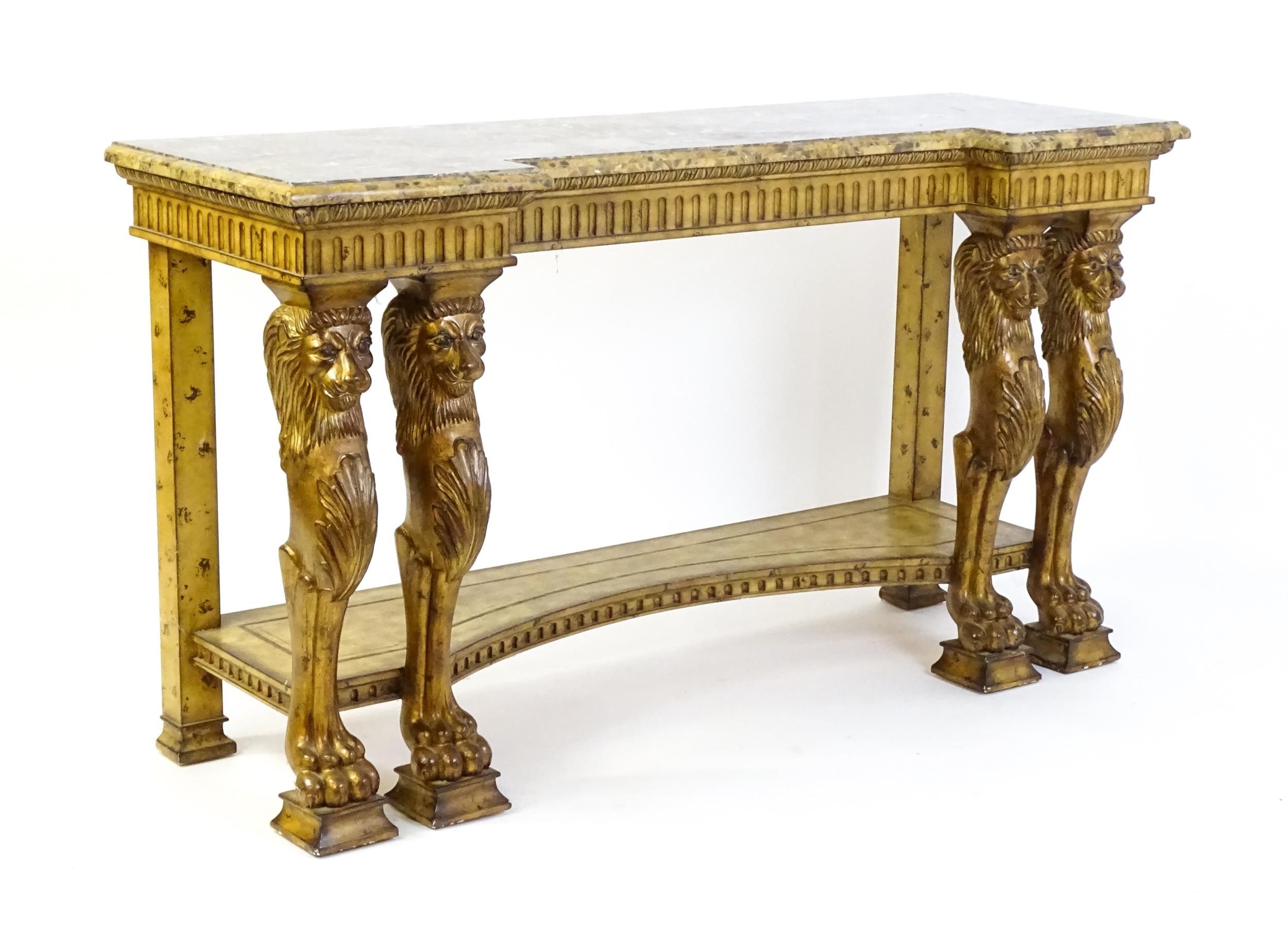 A late 20thC marble and wooden topped inverted break front console table with two pairs of lion