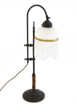 A 20thC adjustable height table / student's lamp, the glass shade with glass drop fringing.