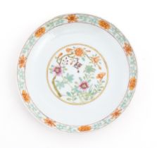 A Chinese famille rose plate / dish decorated with floral and foliate decoration, the reverse with a