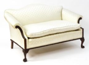 An early 20thC mahogany show wood sofa with a floral carved frame, decorated with blind fretwork