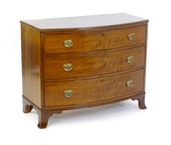 An early 19thC mahogany bow fronted chest of drawers comprising three long drawers raised on