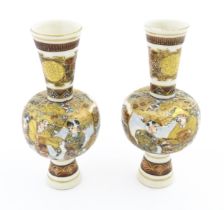 A pair of small Japanese satsuma vases with elongated necks decorated with figures and banded