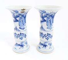 A pair of Chinese blue and white vases with flared rims, decorated with figures on a terrace with