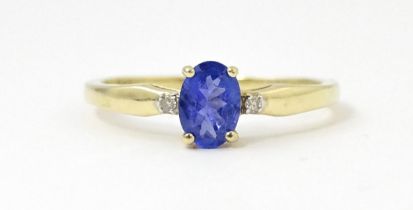 A 9ct gold ring set with central blue stone flanked by two diamonds. Ring size approx. R 1/2