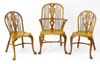 A group of three Stewart Linford yew wood Windsor chairs. The double bow back armchair with a