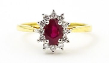 An 18ct gold ring set with central ruby bordered by diamonds. Ring size approx. M Please Note - we