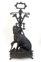 A 20thC cast stick / umbrella stand decorated with a seated terrier dog with crossed walking sticks,