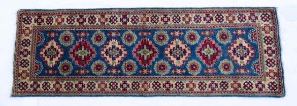 Carpet / Rug : A Turkish kazak runner, the blue ground decorated with repeating medallions with