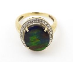A 9ct gold ring set with central ammolite bordered by diamonds. Ring size approx. N Please Note - we