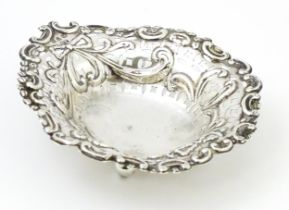 A Victorian silver bon bon dish with pierced decoration and raised on ball feet, hallmarked
