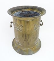 An Art Nouveau brass jardiniere / coal bucket of cylindrical form with flared rim and base and