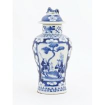 A Chinese blue and white vase and cover with panelled decoration depicting figures in a landscape
