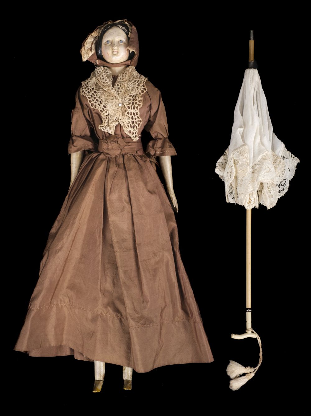 Doll. A large wooden doll with parasol, circa 1840