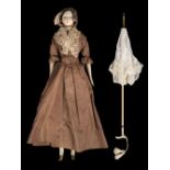 Doll. A large wooden doll with parasol, circa 1840