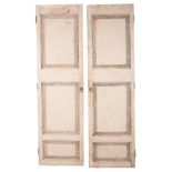 A LARGE PAIR OF WHITE-PAINTED AND DISTRESSED SHUTTERS OR DOORS
