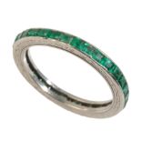 AN EMERALD AND PLATINUM FULL ETERNITY RING