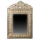 A CHARLES II STYLE REPOUSSE WHITE METAL AND EBONY MIRROR