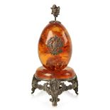 A RUSSIAN AMBER AND SILVER MOUNTED EGG ON STAND