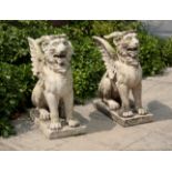 A PAIR OF COMPOSITE STONE GRIFFONS
