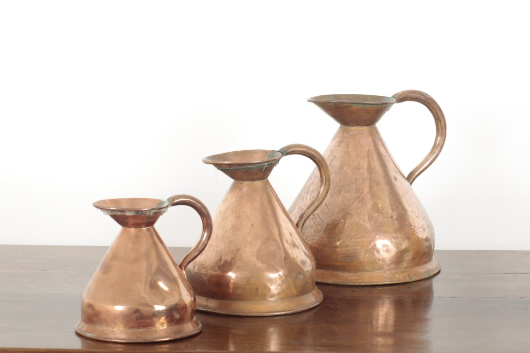A GROUP OF THREE GRADUATED COPPER JUGS