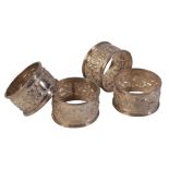 A SET OF FOUR INDIAN WHITE METAL NAPKIN RINGS