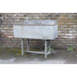 A GALVANISED METAL TROUGH ON STAND