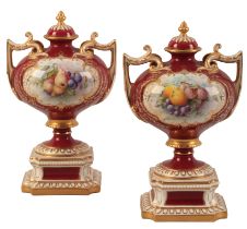 A PAIR OF ROYAL WORCESTER URNS AND COVERS
