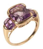 A 9CT GOLD AND AMETHYST THREE STONE RING