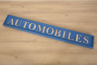 A PAINTED WOOD ADVERTISING SIGN FOR 'AUTOMOBILES'